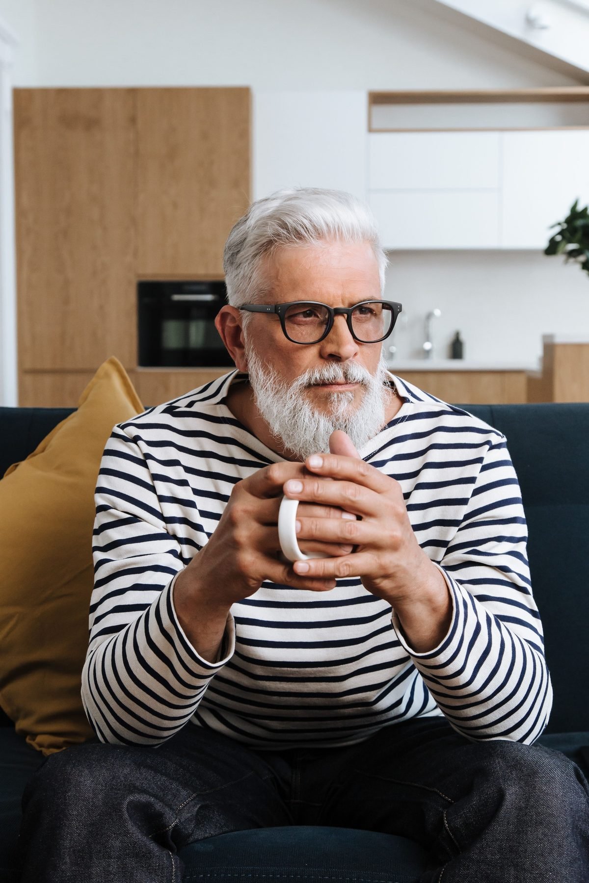 Relieved older man sitting calmly at home holding a warm drink after finding a natural prostate method